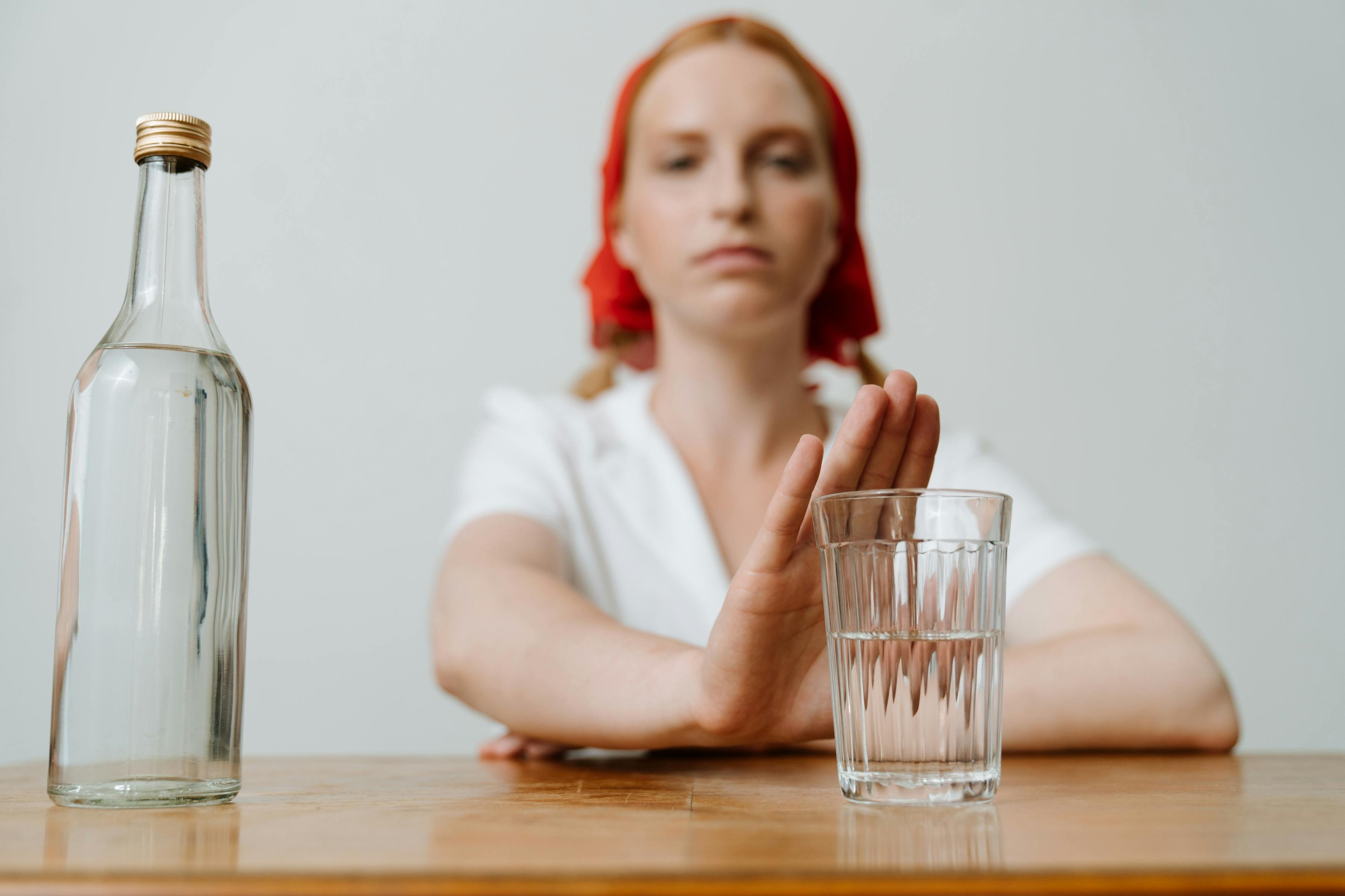 woman rejecting glass of water with hand