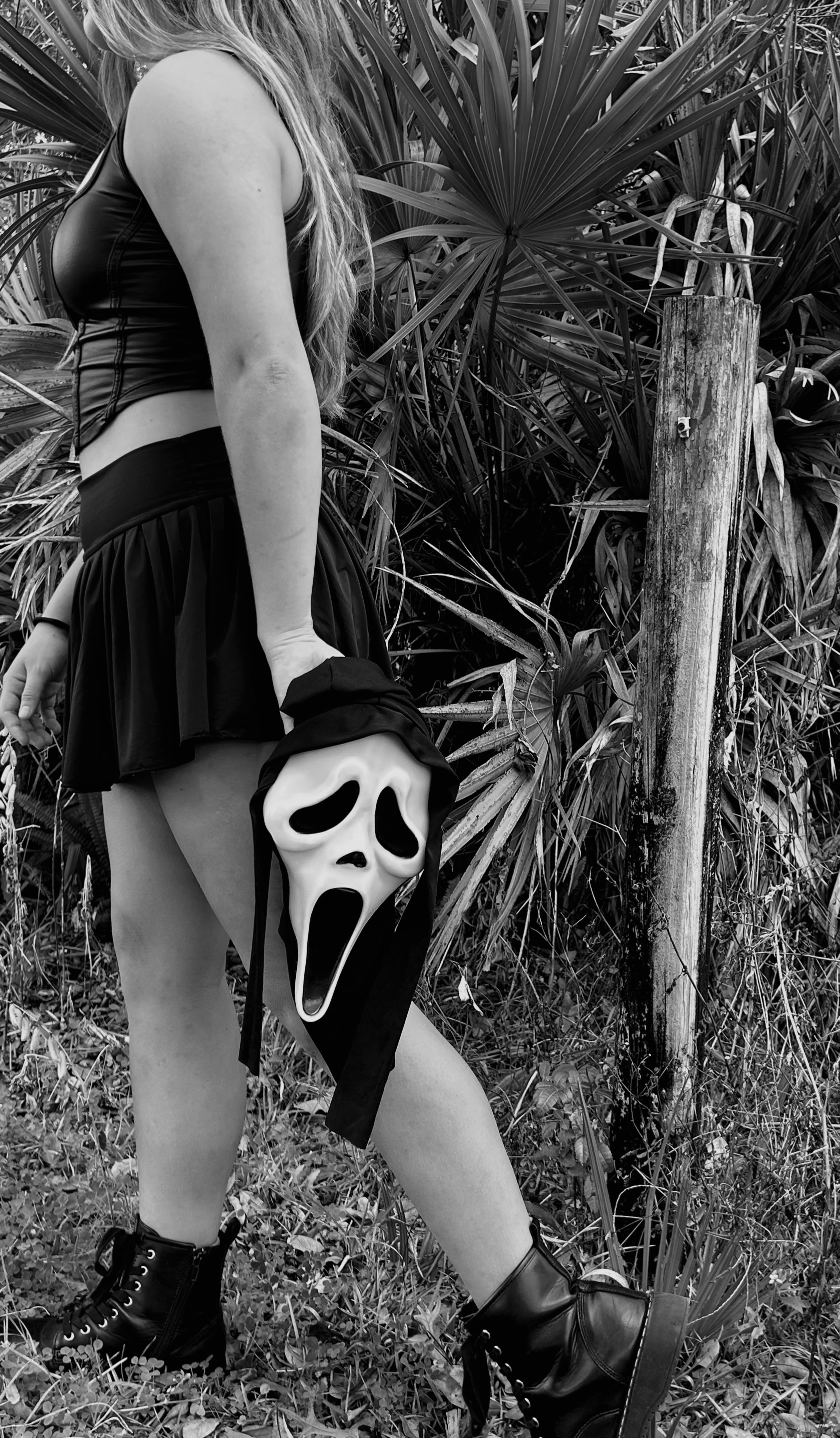 Faceless girl holding ghostface mask walking away