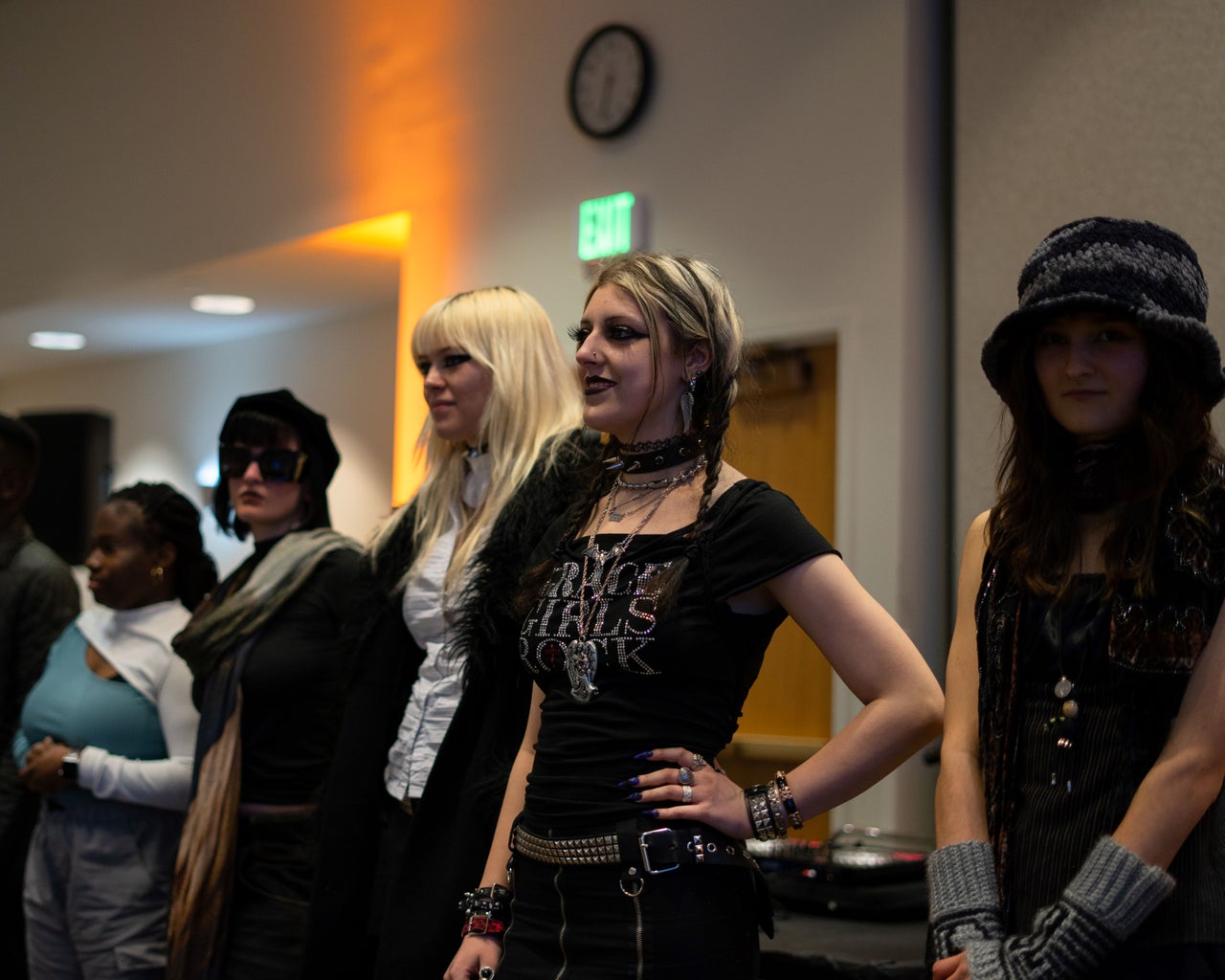 Women in dark clothing lined up at a fashion show