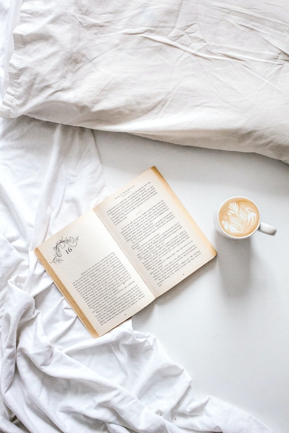 book with latte in bed