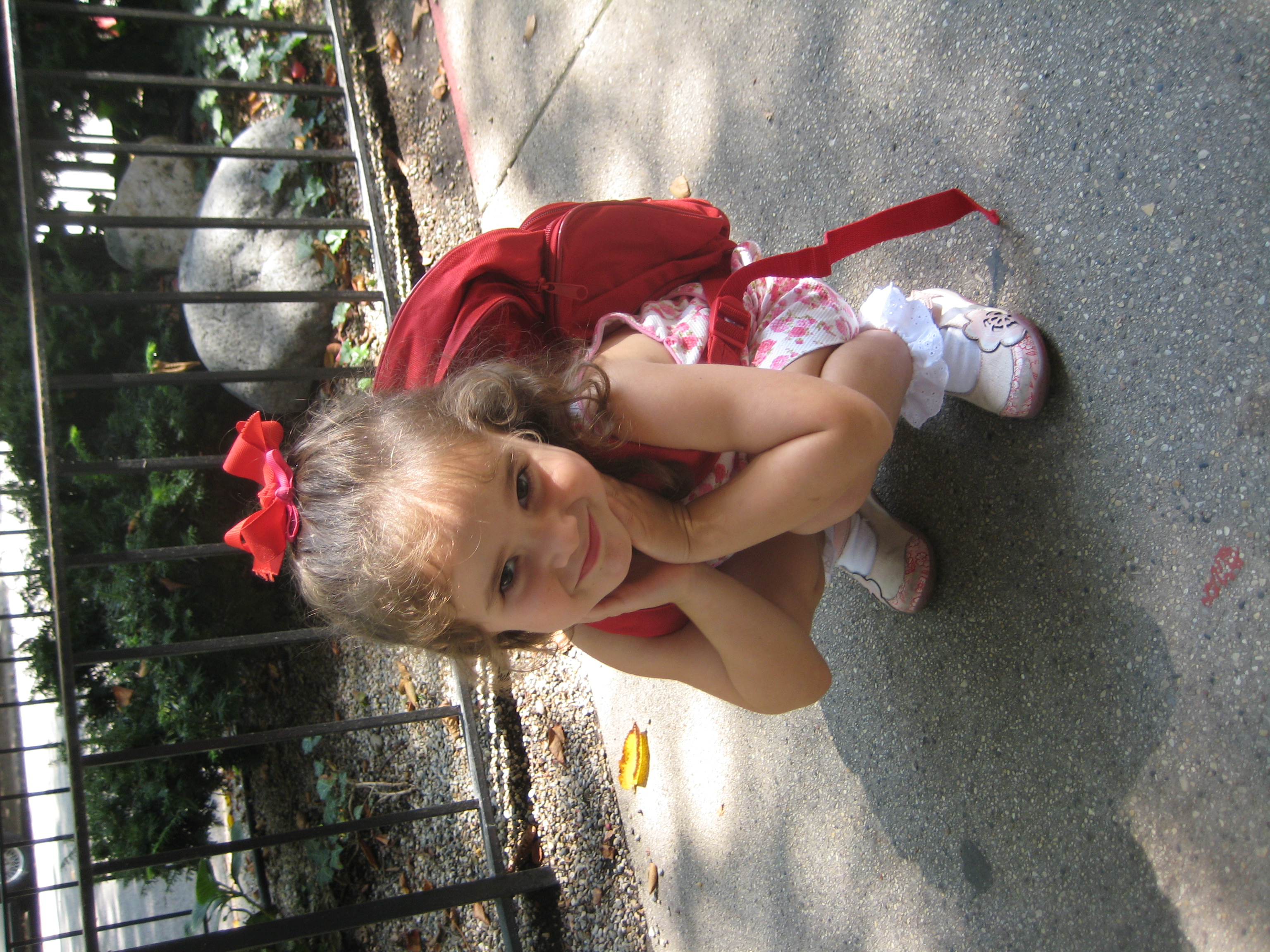 young girl poses in front of preschool