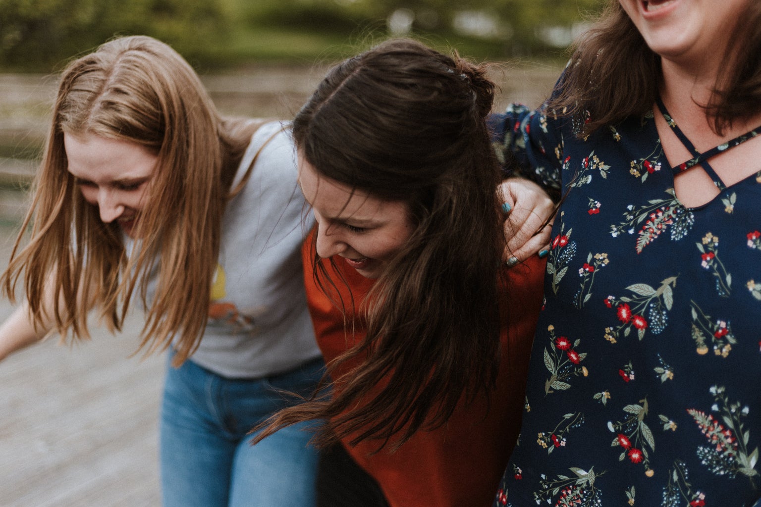 three women holding each other and smiling and laughing