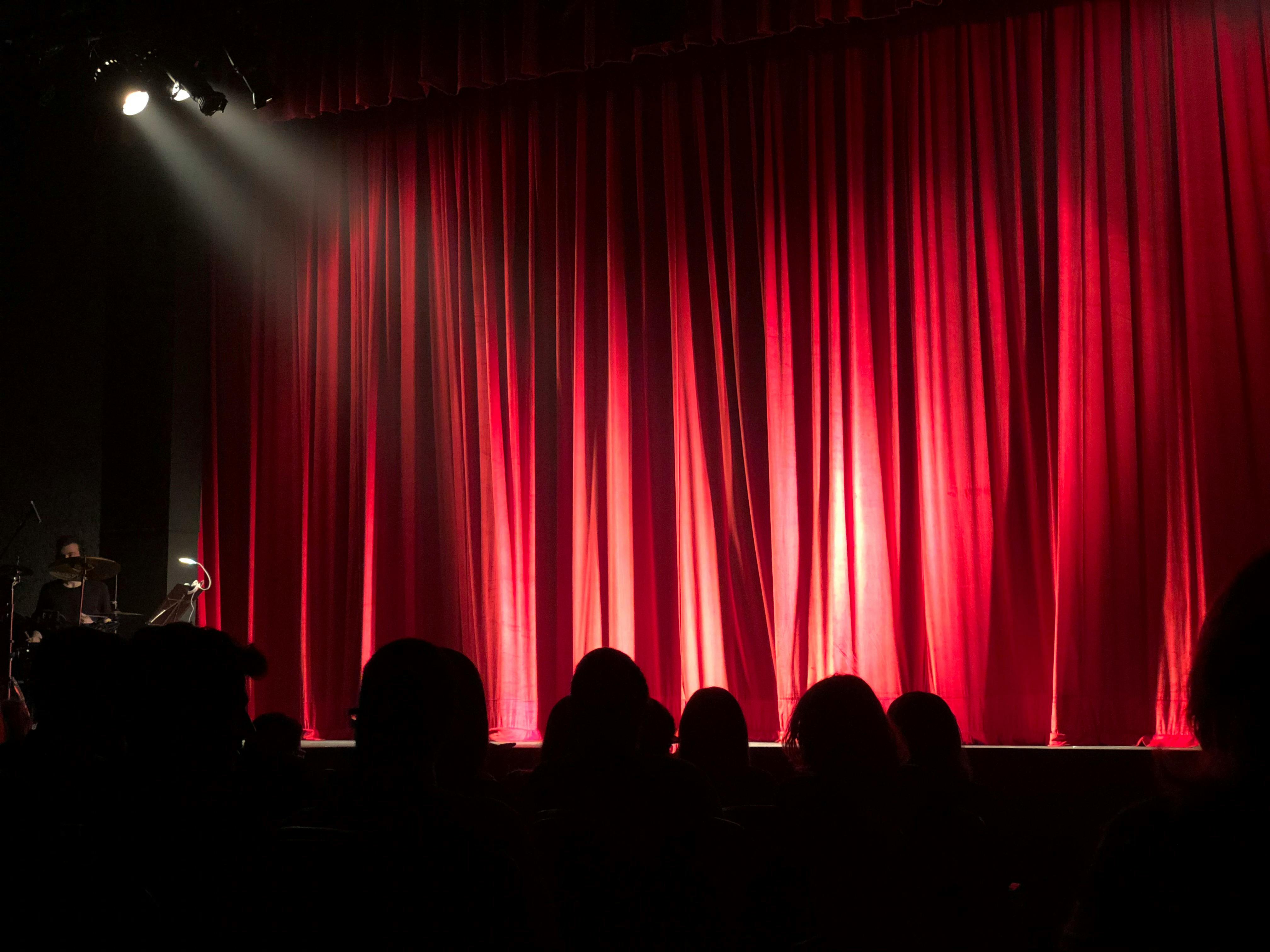 People at a theater: red curtain