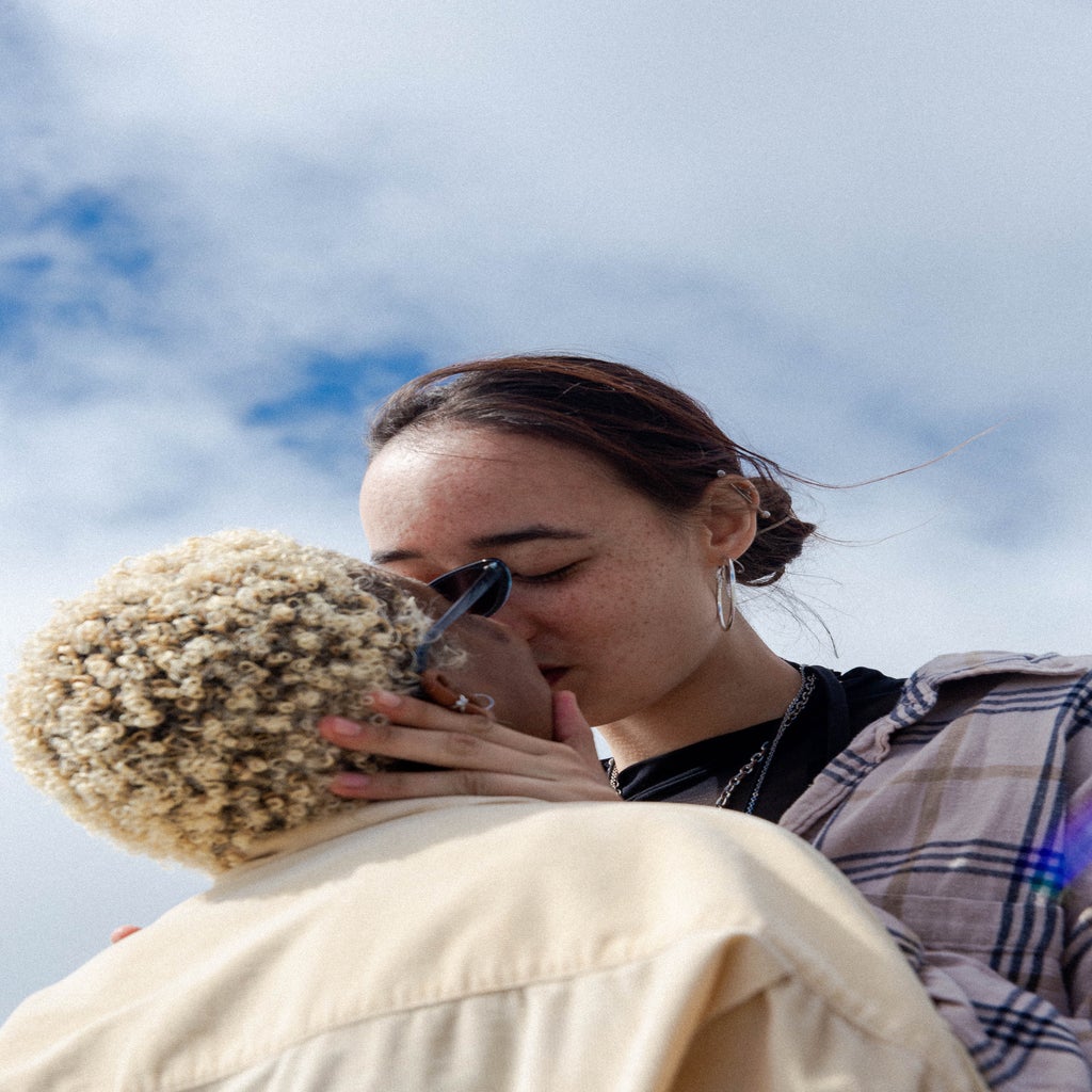 queer couple kissing outside