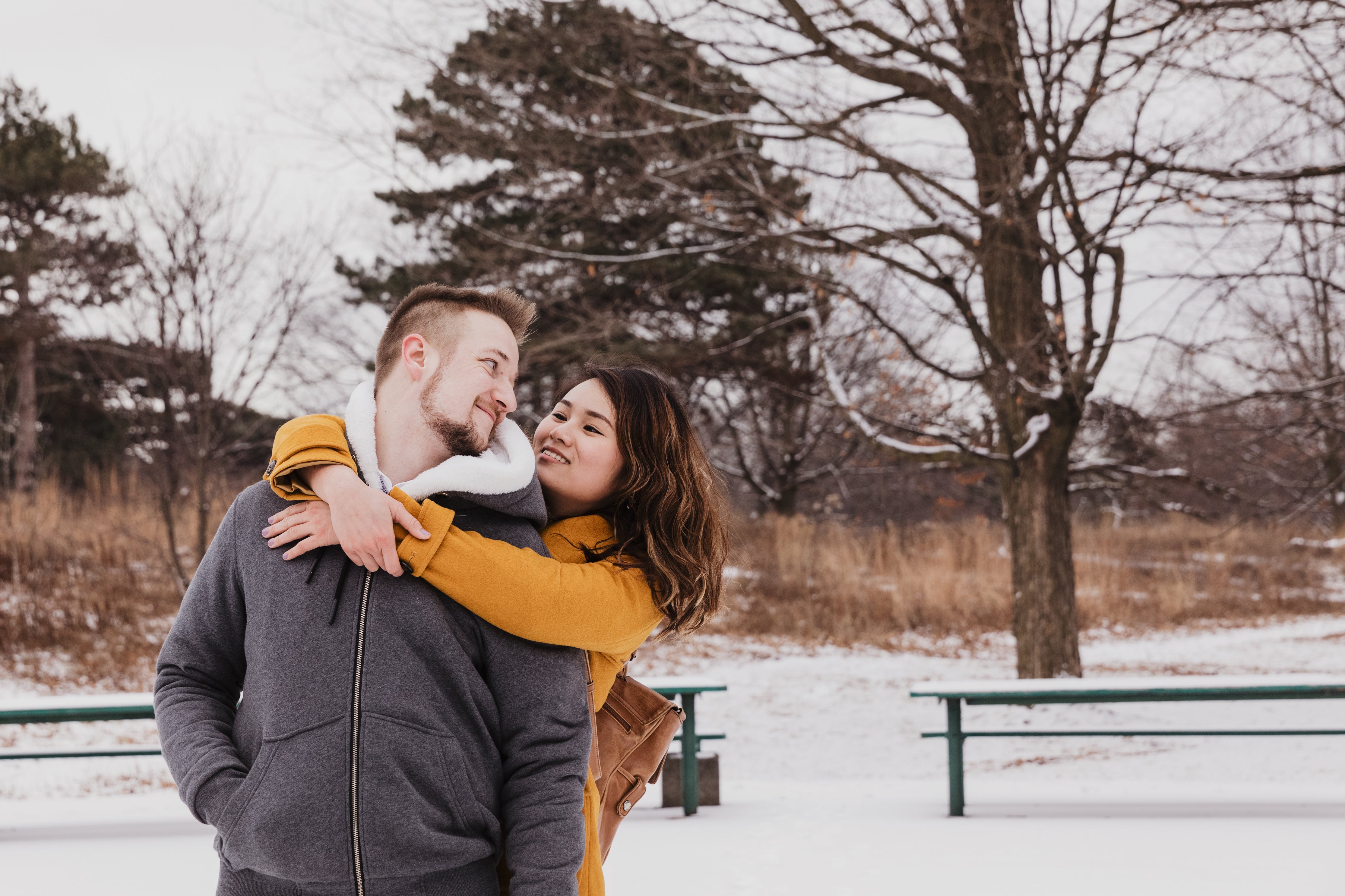 Couple hugging in the snow.