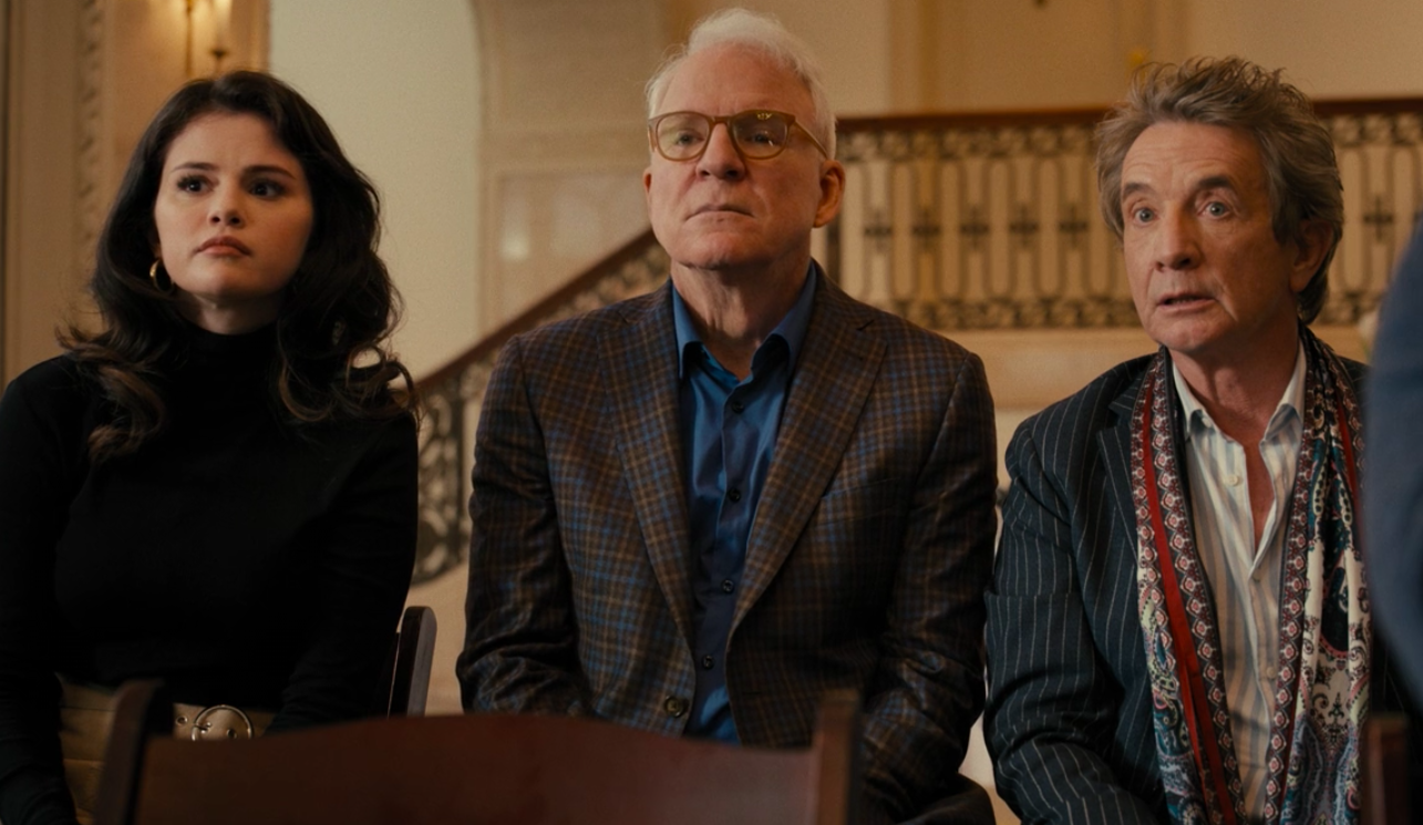 A young woman and two older men sitting beside each other