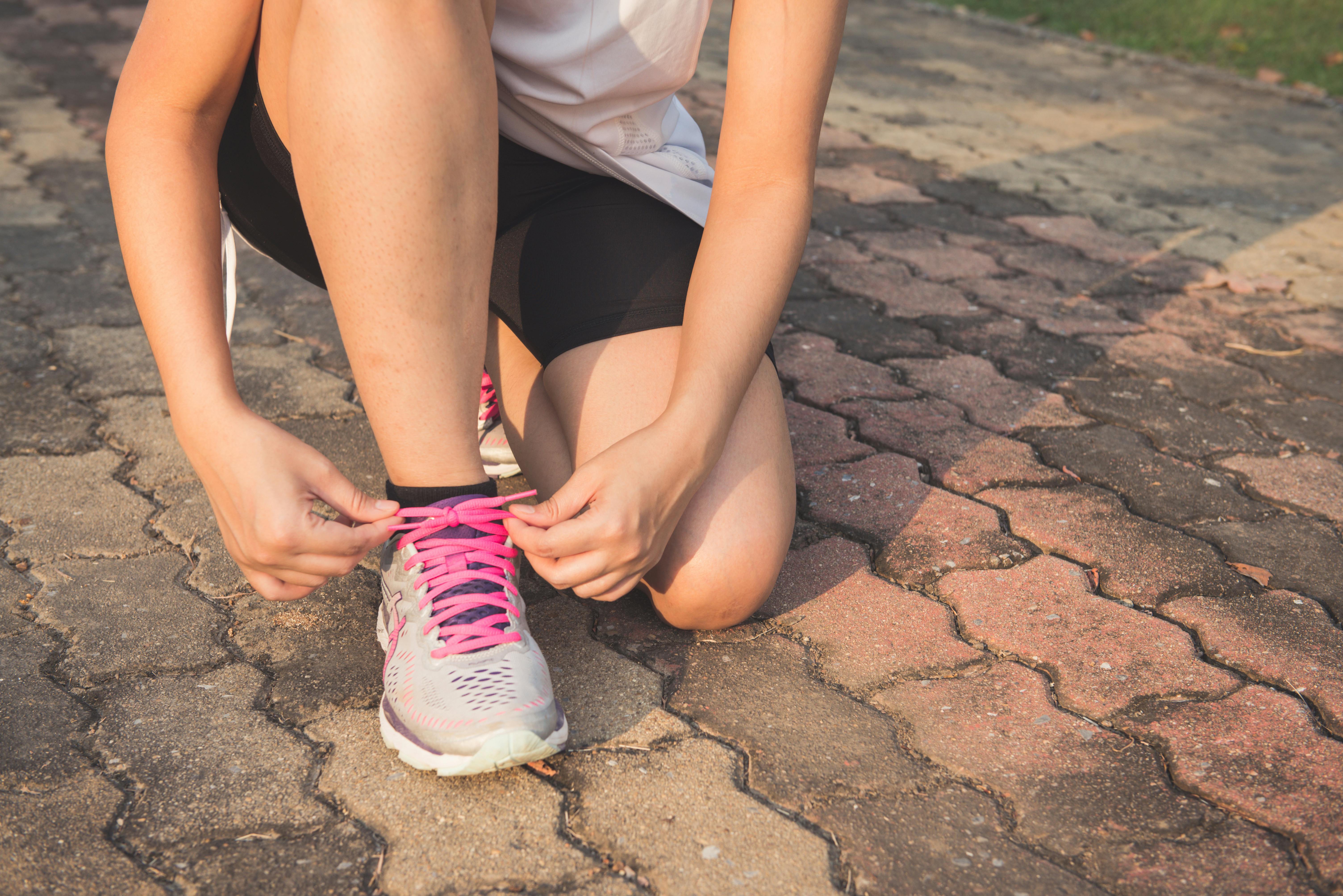 girl tying running sneakers