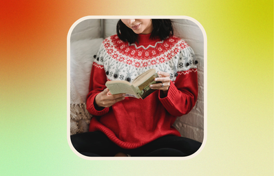 woman reading book in holiday sweater