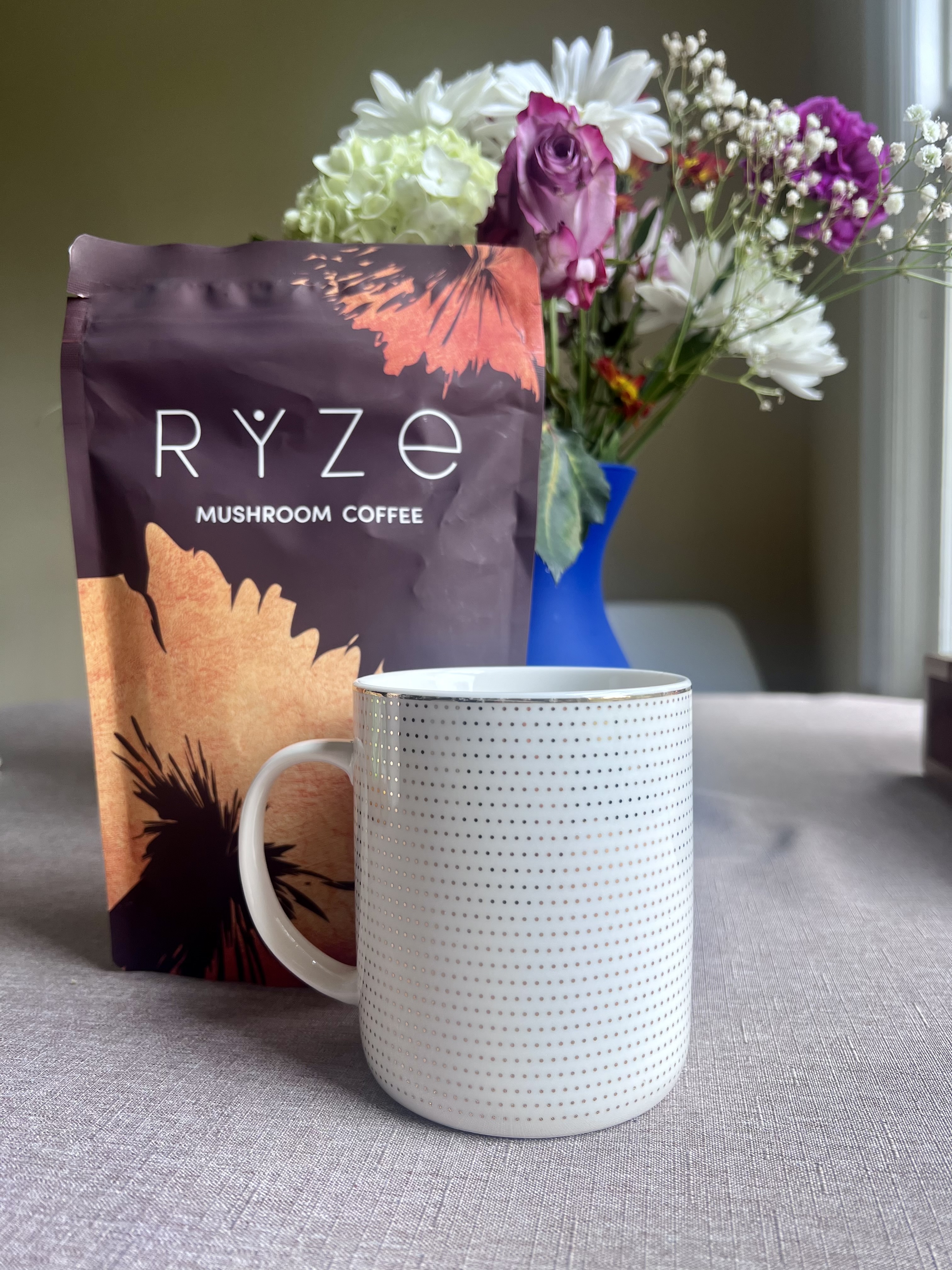 A cup of coffee in front of RYZE instant coffee
