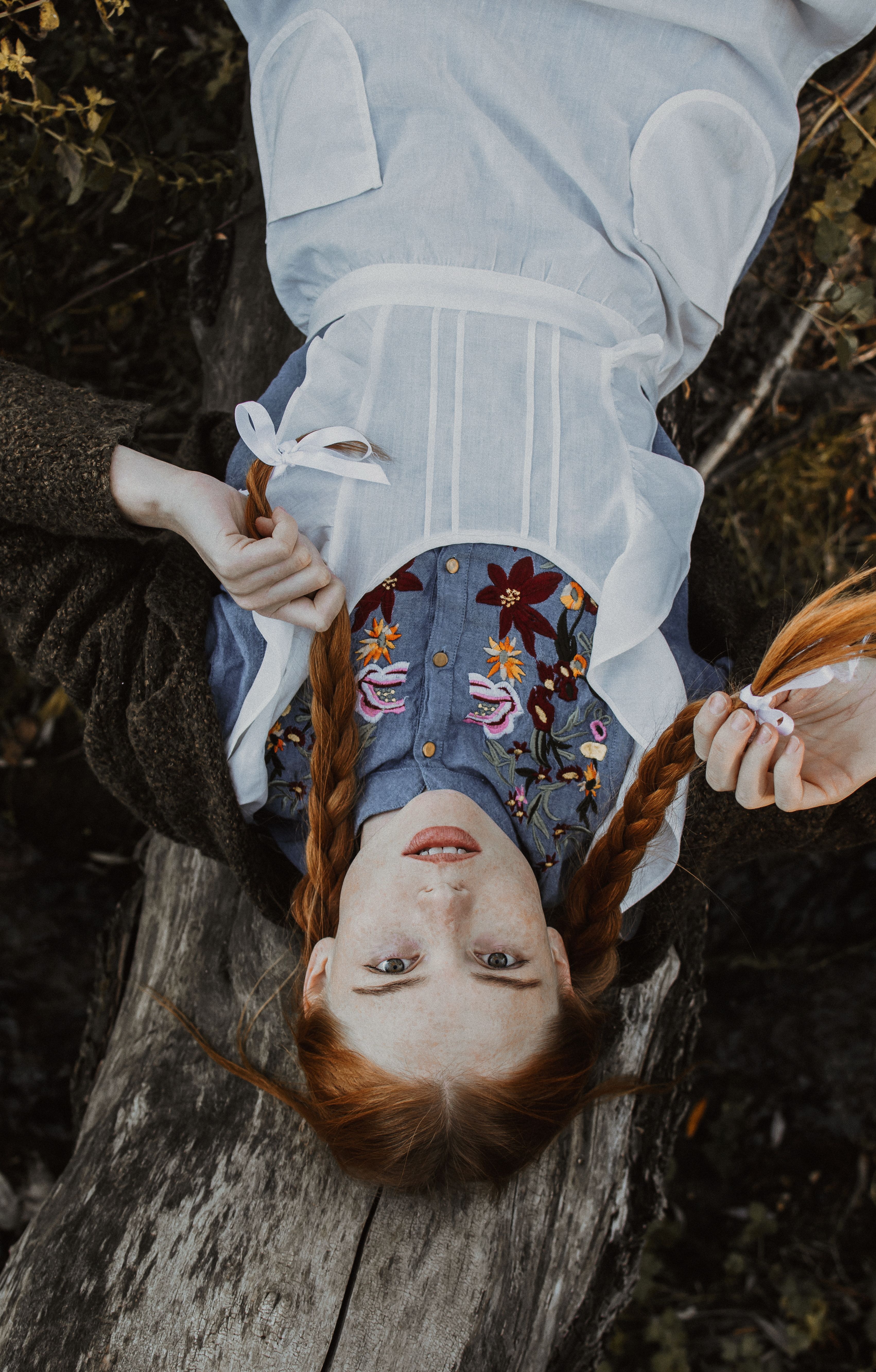 girl laying on tree looking up