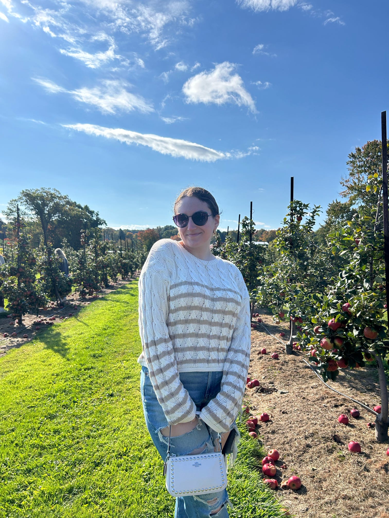 author standing in an apple orchard