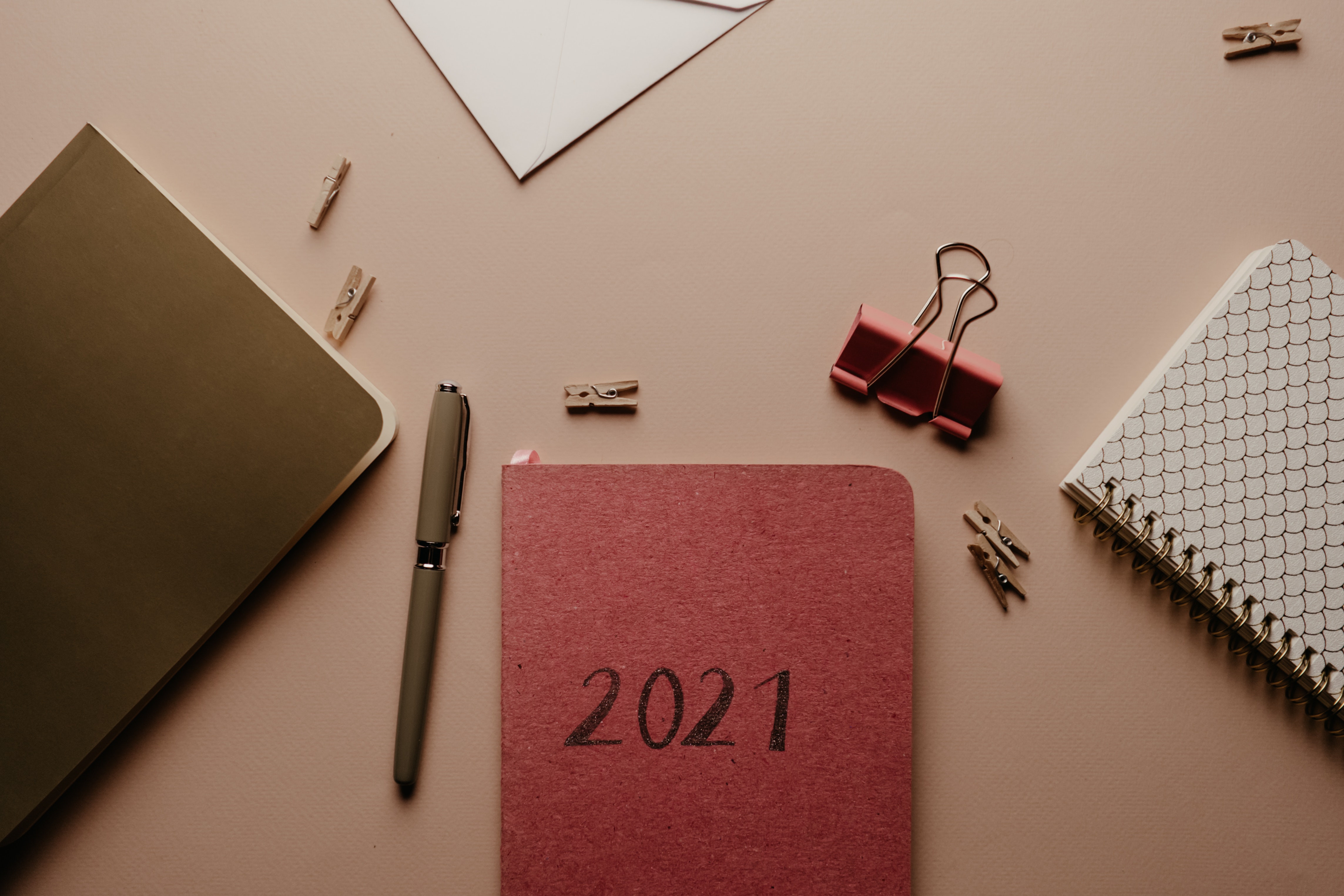 Desk with stationary, an agenda, pens, paperclips, and a binder clip