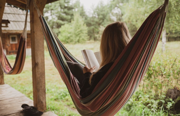 woman reading a book on hammock